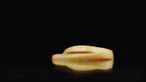 Grapefruit-rings-sliced-fall-on-the-glass-with-splashes-of-water-in-slow-motion